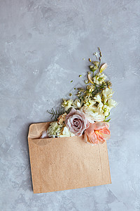 灰色石头背景上信封里的花给你的邮件春天的背景平躺信封里花图片