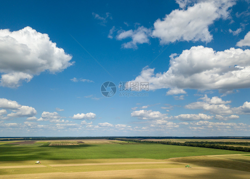 风景如画的乡村景观,蓝天白云,农田,草地,绿树夏天无人机的全景美丽的农田景观的无人机全景,日落时蓝色多云的天空的背景上图片