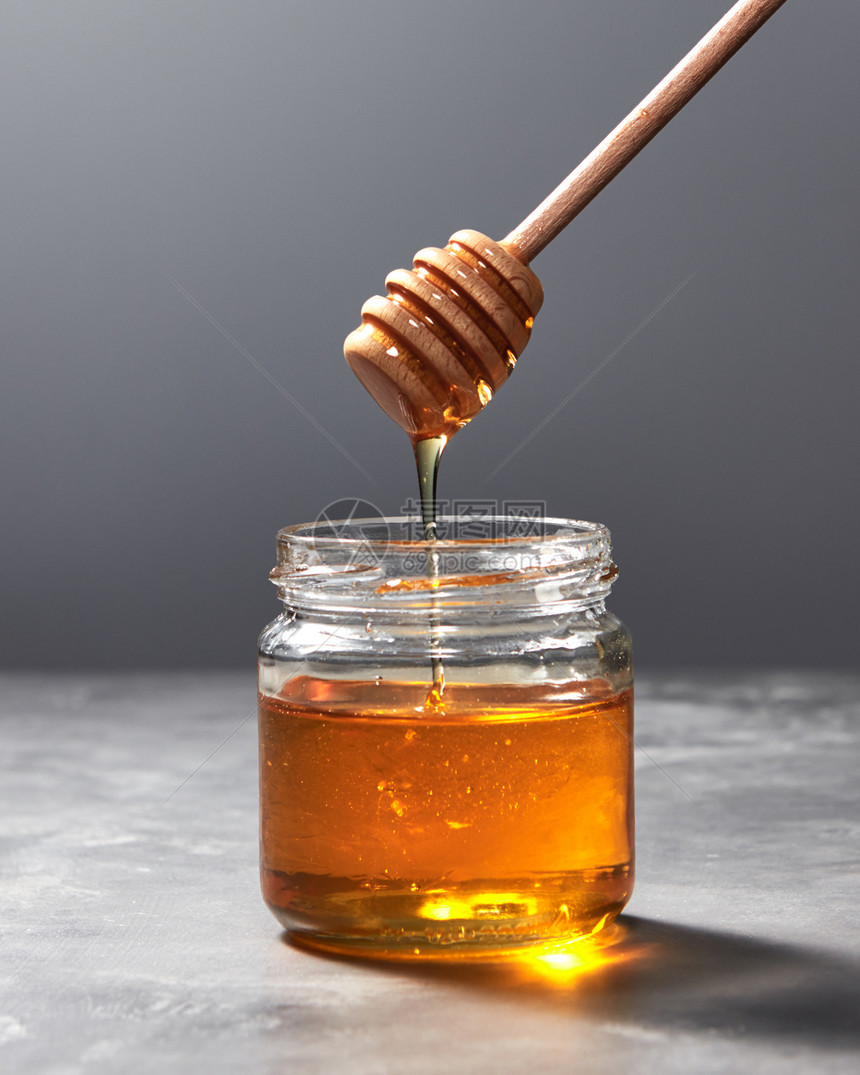 将机天然新鲜蜂蜜璃壶滴灰色厨房石材背景上,并犹太罗什哈沙纳假日芬芳的机新鲜蜂蜜木棒滴璃壶上的图片