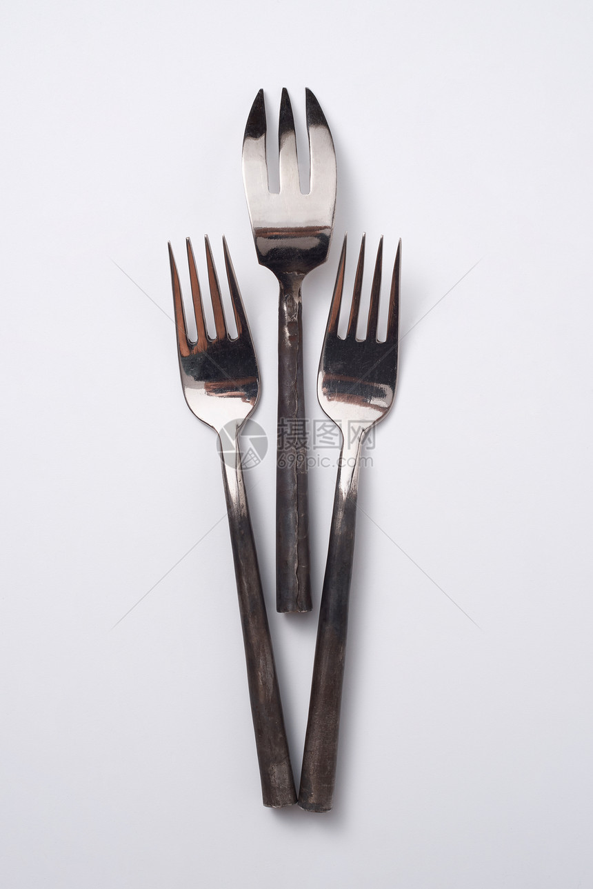 同的金属老式叉子隔离灰色背景与弗莱莱三个金属同的老式叉子灰色背景与的文本平躺图片