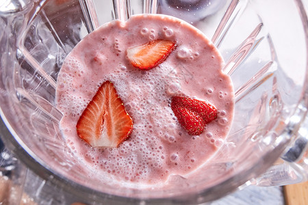 自制的健康奶昔甜点,草莓片放搅拌机碗里的风景刚准备好的草莓冰沙放搅拌机碗里健康的食物的风景图片