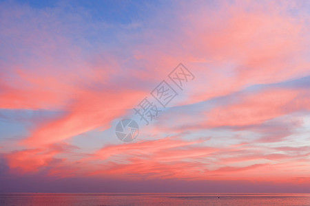 粉色海滩日落时的蓝天,带着彩色的云,生活海洋周围的珊瑚自然美丽的背景夕阳下,大海的背景下,看蓝色的粉红色的天空云彩背景