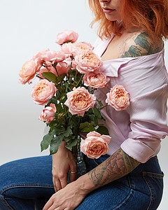 纹身象征个璃花瓶与精致的粉红色玫瑰持个女孩与纹身周围的灰色背景与文字母亲节花瓶里粉红色的玫瑰,抱着个灰色背背景