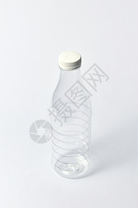 透明盖子塑料透明空瓶,用于乳制品,水其他液体与白色杯子浅灰色背景上,模拟透明的空瓶,用于轻背景上的液体嘲笑背景