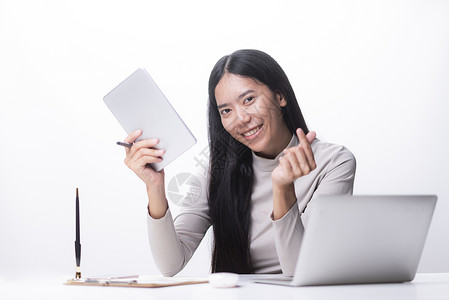 个吸引力的中女商人坐笔记本电脑前,家管理她的小生意图片