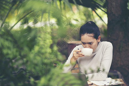 早晨咖啡早餐户外咖啡馆的个身份明的轻女人的手背景图片