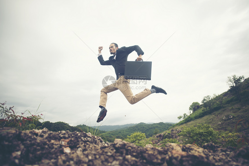 快乐的商人跳跃喊叫,成功的企业人士山顶上大喊大叫,庆祝成功的喜悦图片