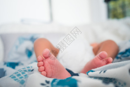 个新出生的孩子躺柔软的床垫上的脚图片