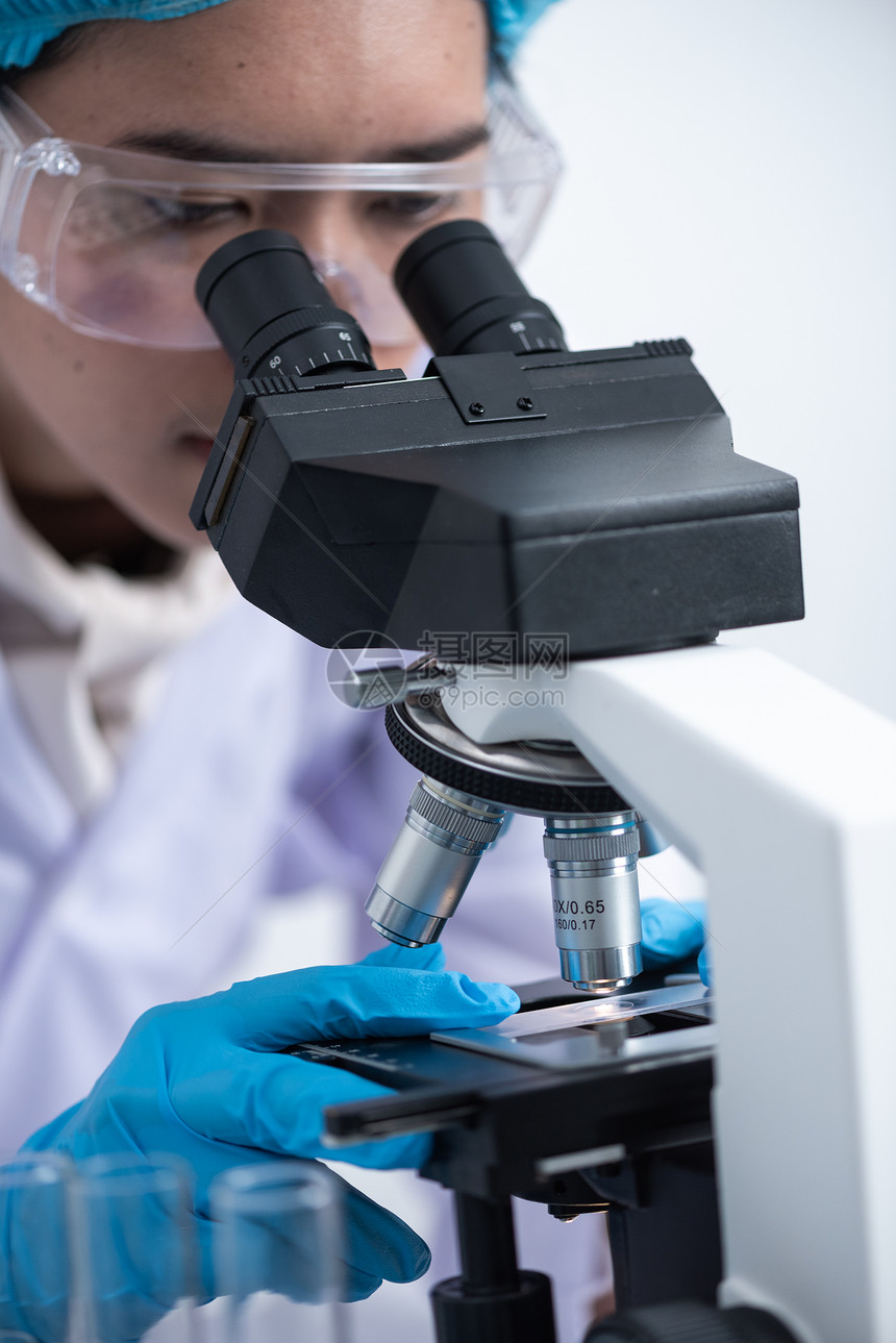 科学家正用显微镜用于实验室实验图片