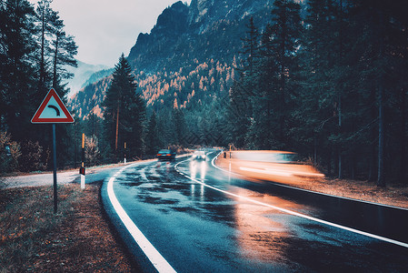 风里雨里秋天的森林里,道路上模糊的汽车雨中运动阴雨天完美的沥青山路巷道,意大利阿尔卑斯山的松树运输雾林中的公路旅背景