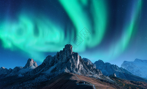 天峰欧洲夜间山上的北极光北极光天空中北极光高岩石的星星美丽的景观与极光,建筑山上,山脊旅行背景