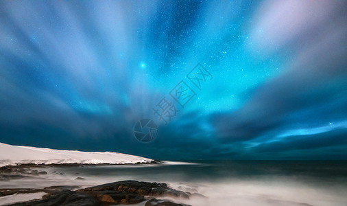 卡磁瓦斯炉惊人的北极光俄罗斯泰伯卡的北极光星空与极地的灯光云彩夜间冬季景观与极光,大海与石头模糊的水,雪山旅行背景