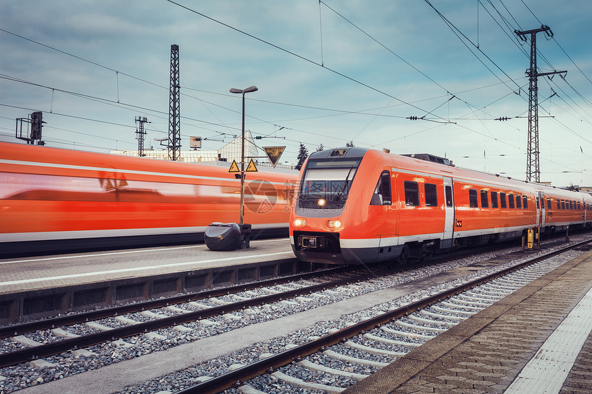现代高速红色客运通勤列车铁路站台日落与复古色调火车站运动模糊效应的铁路工业景观旅行火车图片
