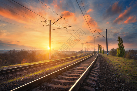 火车站日落时迎着美丽的天空工业景观与铁路,彩色蓝天与红云,太阳,树木绿草铁路枢纽重工业秋天的傍晚背景图片