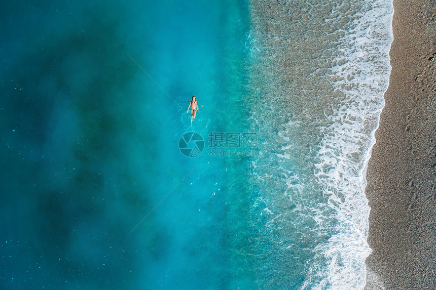 土耳其奥卢德尼斯地中海游泳妇女的鸟瞰图美丽的夏季海景与女孩,清澈的蔚蓝的水,波浪沙滩阳光明媚的日子飞行无人机的顶部视图片