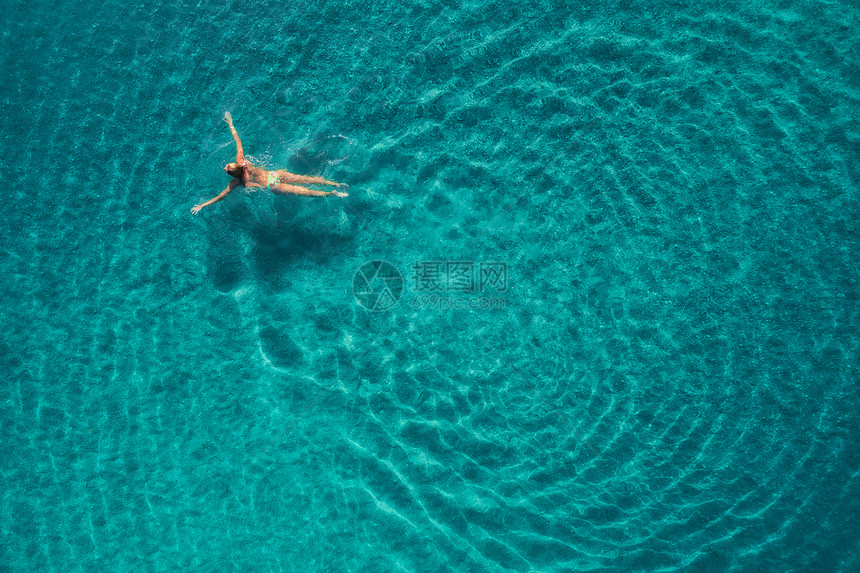 蓝色泻湖游泳女子的鸟瞰图土耳其奥卢德尼茨的地中海夏天的海景与女孩,清澈的蔚蓝的水,波浪阳光明媚的日子透明的水飞图片