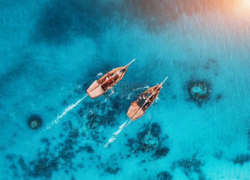 夏天日落时,透明的蓝色水中俯瞰渔船非洲桑给巴尔印度洋漂浮船的无人驾驶飞机上俯瞰景观与游艇清澈的大海海景图片