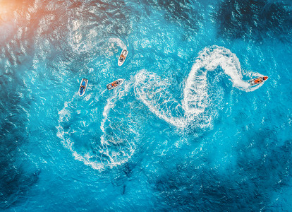 比利茨基浮动夏季日落时蓝色水中浮水滑板车的鸟瞰图印度洋,桑给巴尔,非洲度假喷气滑雪运动的顶部视图热带海景与移动摩托艇极端背景