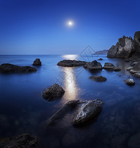 五颜六色的夜景,满月,月径岩石夏天海上的山景背景图片