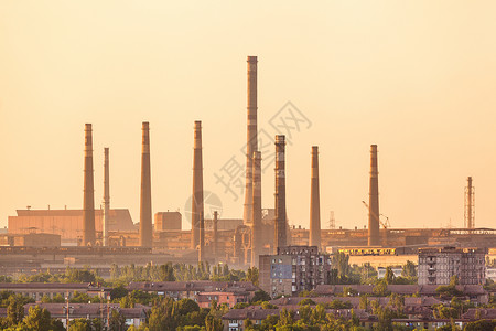 城市建筑背景上的钢铁工厂与烟囱五颜六色的日落冶金厂钢铁厂,钢铁厂欧洲的重工业烟囱的空气污染工业景观背景图片