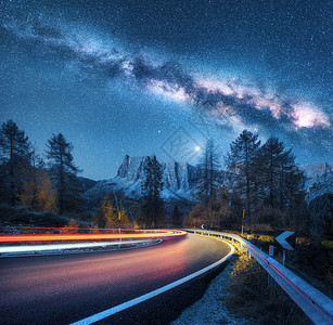 夜照银河山路上秋天蜿蜒的道路上模糊的汽车前灯五颜六色的夜景,蓝色的星空,银河,月光,光小径,岩石,树木公路背景