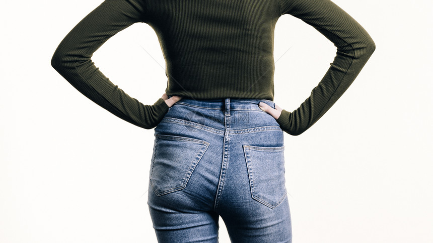 目全非的女人向后站着,穿着紧身的蓝色牛仔裤,露出臀部的曲线穿着蓝色牛仔裤的女人站后图片