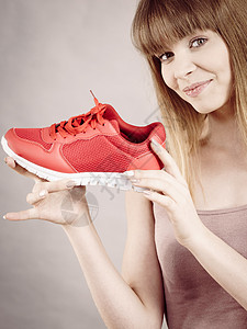 快乐的运动微笑的女人展示运动服装运动鞋红鞋,舒适的鞋类完美的锻炼训练快乐的女人展示运动服装运动鞋背景图片
