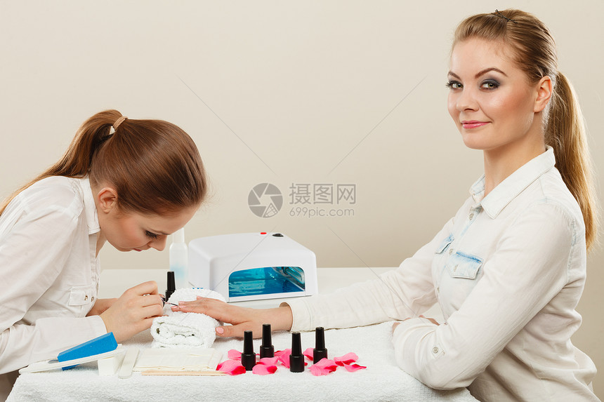 放松时间健康日金发优雅的女人参观专业美甲师沙龙美容师给客户完美的指甲美容师客户美容院图片