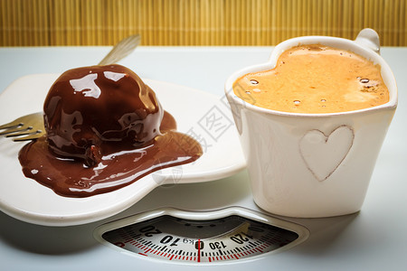 称量秤上的咖啡巧克力蛋糕健康的营养脂肪饮食称重秤上的咖啡巧克力蛋糕图片