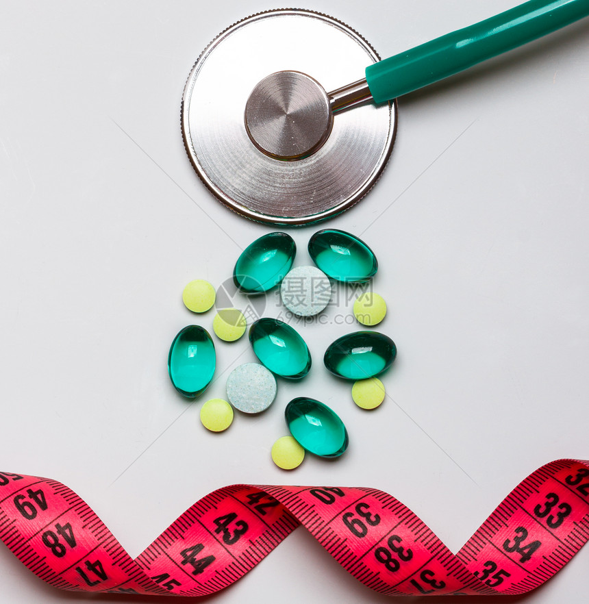 健康饮食医药保健食品补充剂减肥理念桌上测量带听诊器的药丸图片