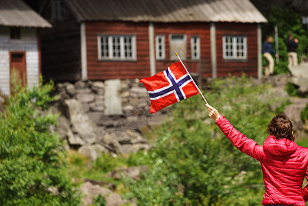 莱克伍德旅游妇女参观乔辛福德的赫勒伦房屋,沿着EgersundFlekkefjord的44号公路,女手持挪威挪威索肯达尔背景