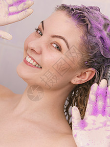 女浴室女人头发上涂上着色洗发水紫色洗涤产品的女家里涂金色女人头发上涂墨粉洗发水背景