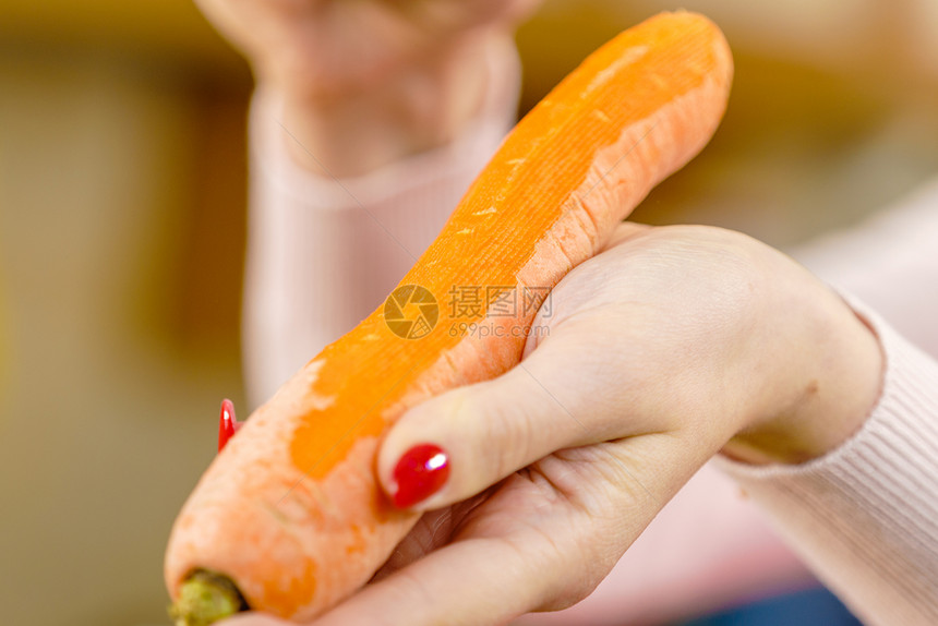 女人用食物剥皮机剥蔬菜烹饪女上菜前先准备胡萝卜图片