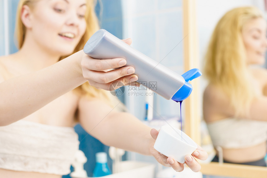 女人把紫色的染发剂洗发水墨粉倒进白色的碗里卫生象妇女倒紫色染发剂洗发水图片