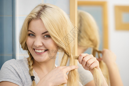轻漂亮的金发女人创造她的发型,辫子可爱的女人准备好了女人金发上辫子图片