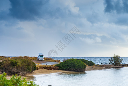 海 货船露营拖车汽车海边多云的夏季天气里,汽车海边的海滩上海边的野营卡车背景