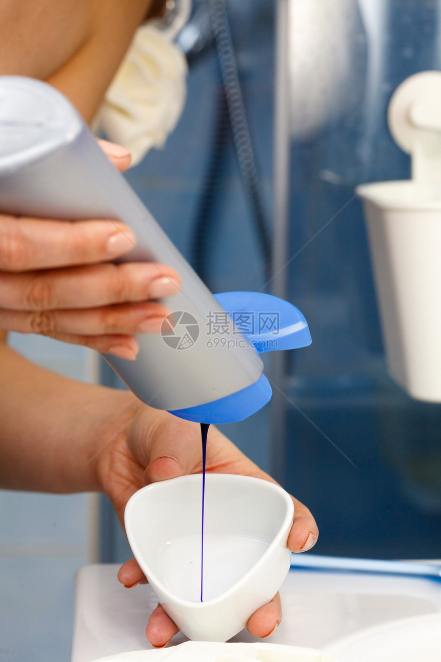 女人把紫色的染发剂洗发水墨粉倒进白色的碗里卫生象妇女倒紫色染发剂洗发水图片