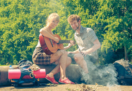 冒险,旅游,享受夏天的时光轻的夫妇游客户外露营时玩吉他图片