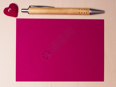 粉红色的白纸,心爱的符号木上的钢笔情人节结婚卡的背景图片