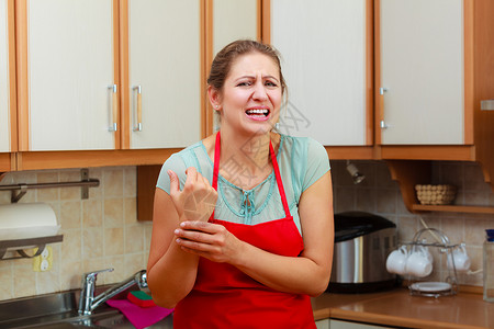 成熟的女人检查手腕上的脉搏厨房里压力很大的女人女人检查手腕上的脉搏图片