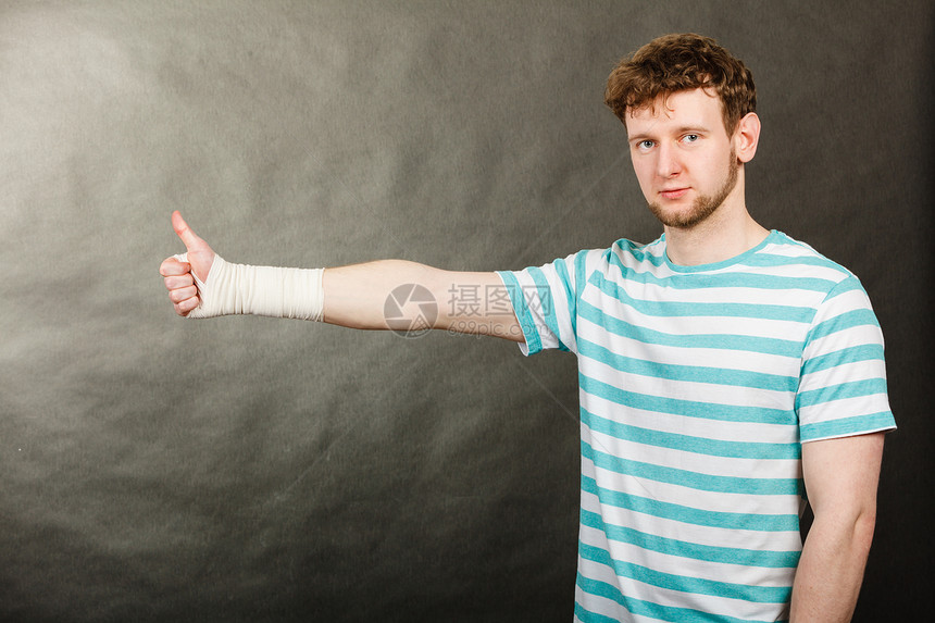 好消息信息医学方男手用绷带拇指标志符号扭伤手腕的快乐的人绷带的手图片