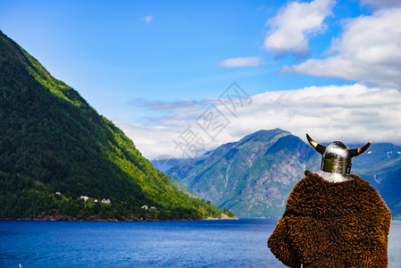 挪威峡湾岸边戴着头盔的维京战士旅游旅游挪威峡湾海岸的维京战士图片