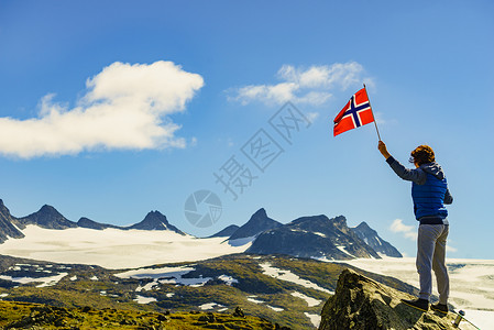 索南达杰游客妇女欣赏山脉景观,举着挪威旅游景区路线55索涅夫杰莱特,挪威山上悬挂挪威的游客背景