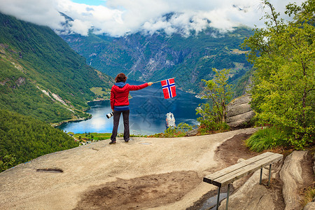 施韦弗利格Flydalsjuvet角度欣赏峡湾Geirangerfjorden风景的女游客,举着挪威巡航度假旅行吉兰格峡背景