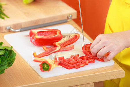 健康饮食,素食,烹饪,饮食人的厨房里的女人家准备新鲜沙拉切片蔬菜红辣椒特写图片