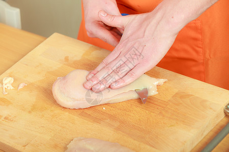 食物准备,烹饪男手厨师切生鸡肉胸木板上图片