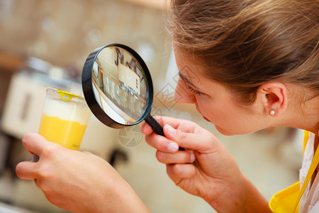 成熟女用放大镜检查甜点食品标签女用放大镜检查食物背景图片