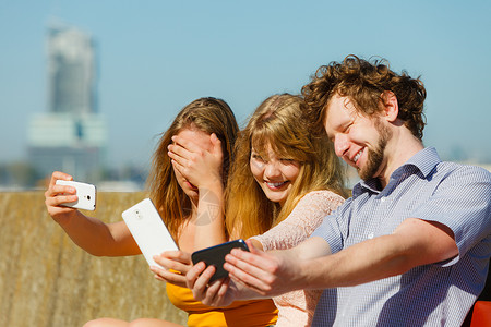 朋友用智能手机自拍自拍照片轻的女人男人户外玩得很开心夏天放松图片