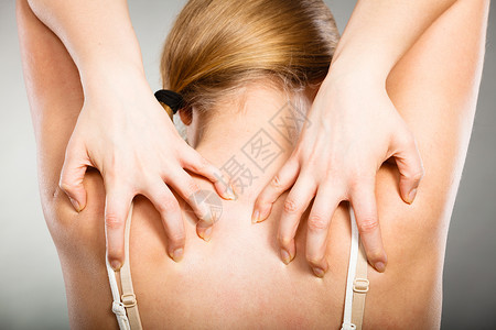 健康问题,皮肤病轻的女人用过敏皮疹挠痒的背部女人用过敏皮疹抓痒背部图片
