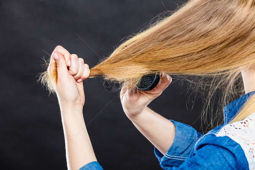 日常卫生关心好的外观背的金发休闲女孩梳理她的长发女人用黑色梳子梳头发金发女人梳头发图片